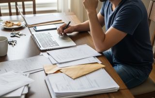 self-employed person working from home at a dining table with a laptop